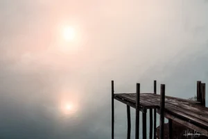 Photographie d'art ponton en bois sur un lac brumeux au lever du soleil, reflets dorés et bleus, ambiance zen et contemplative - Le Seuil des Songes par Hadrien Leloup