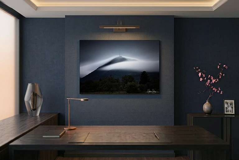 Contre-collage sur Dibond, accroché au mur d'un bureau bleu, sous une applique et en lumière naturelle.